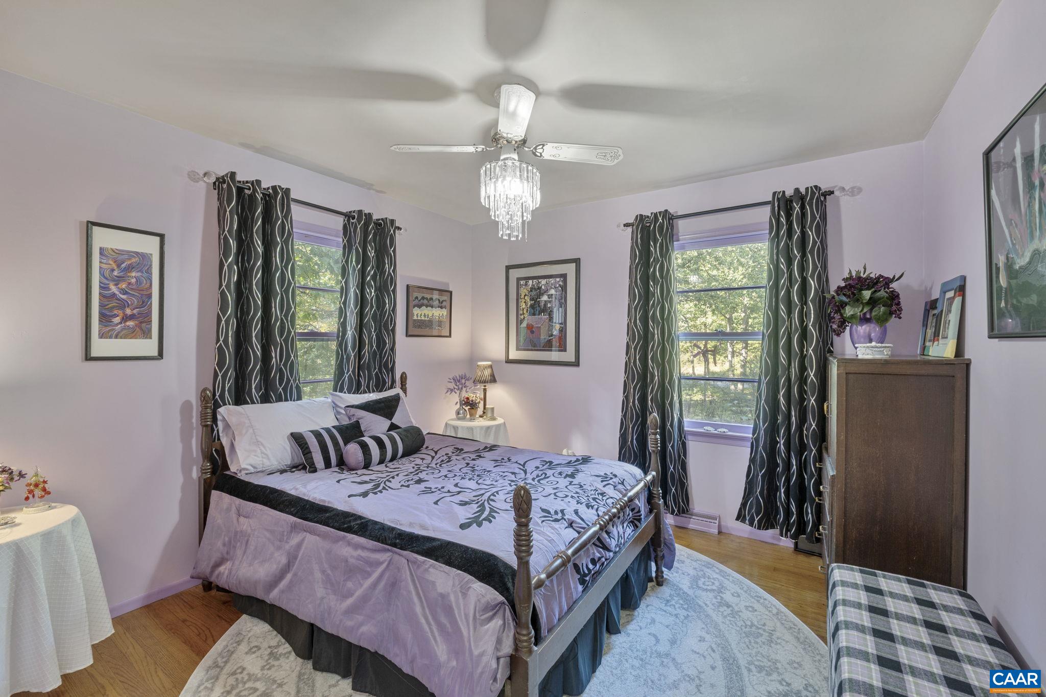 9020 West River Road Palmyra, VA 22963 - Photo 16 of 41 a bedroom with a large bed and a chandelier