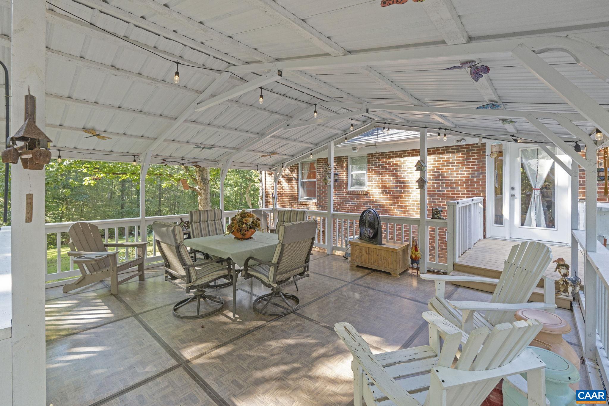 9020 West River Road Palmyra, VA 22963 - Photo 23 of 41 a view of a patio with a dining table chairs and a grill