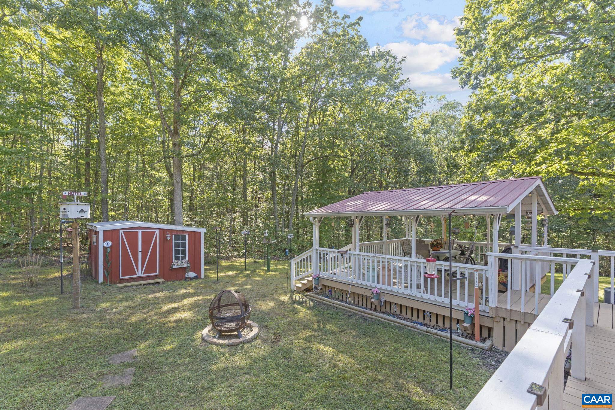 9020 West River Road Palmyra, VA 22963 - Photo 32 of 41 a view of a deck with a table and chair under an umbrella
