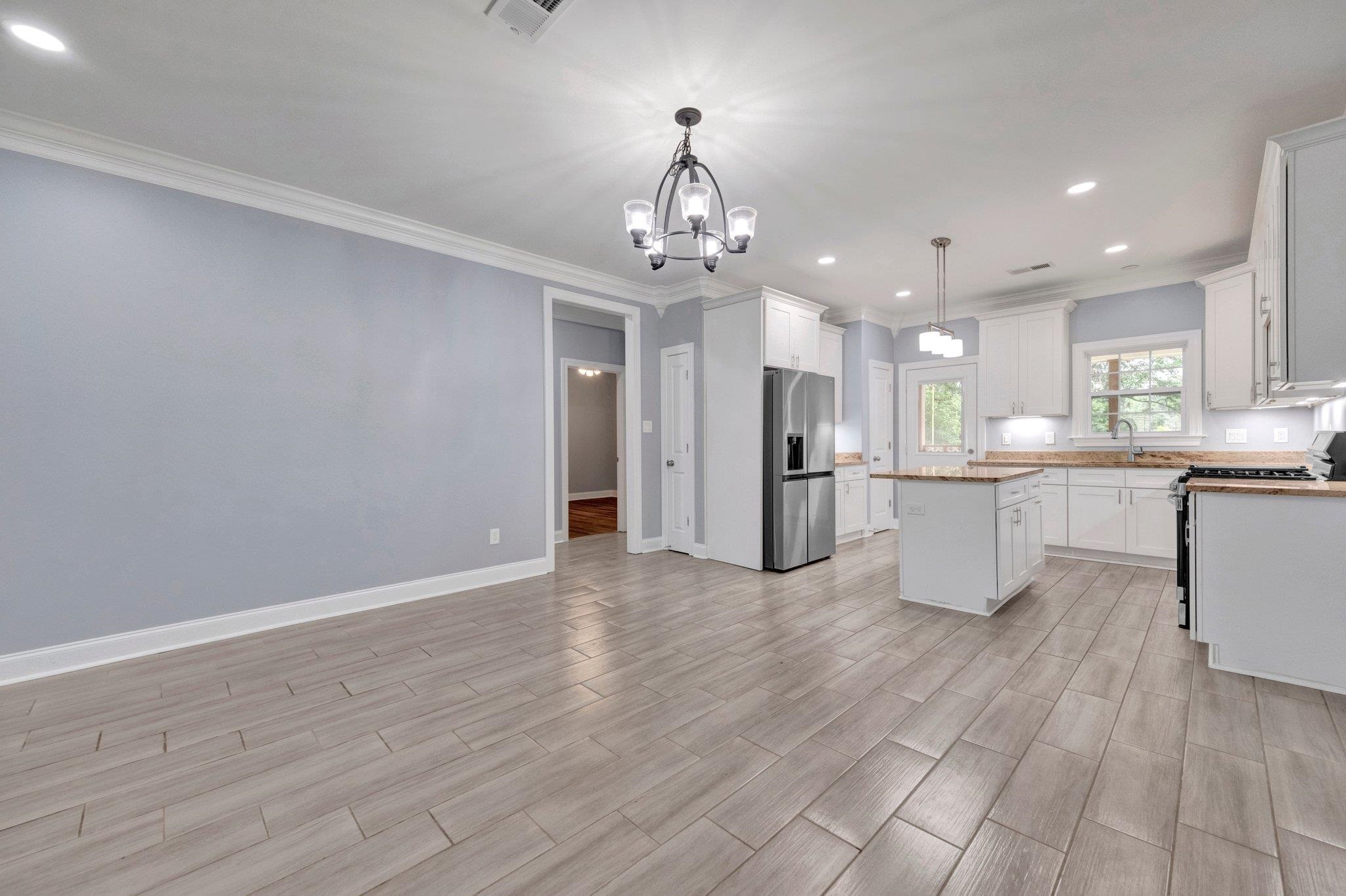 8077 Ellis Road Bartlett, TN 38133 - Photo 8 of 29 Kitchen featuring appliances with stainless steel finishes, a chandelier, a kitchen island, ornamental molding, and a sink