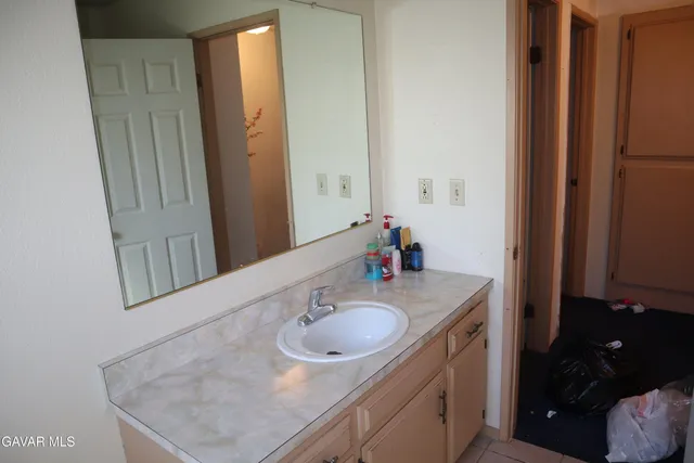 a bathroom with a sink vanity granite and a mirror