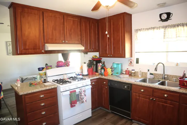 a kitchen with granite countertop wooden cabinets and white appliances