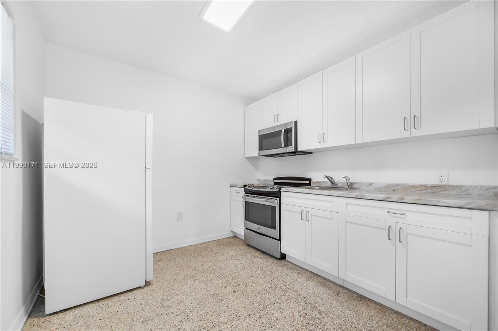 2661 Southwest 11th Street, Unit 8 Miami, FL 33135 - Photo 2 of 9 a kitchen with granite countertop white cabinets and stainless steel appliances