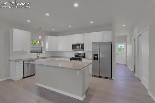 a kitchen with stainless steel appliances granite countertop a refrigerator stove top oven and sink