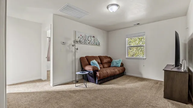 a living room with furniture a window and a flat screen tv