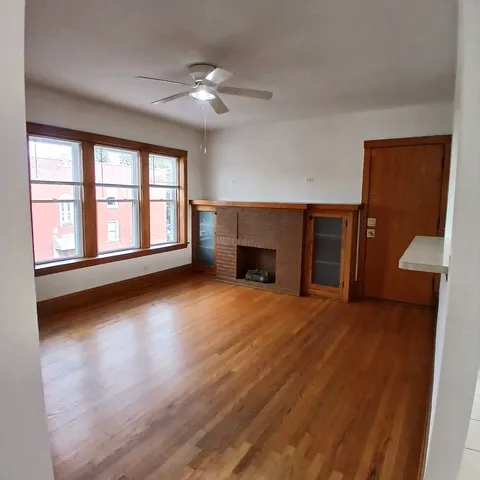 a view of an empty room with a window and fireplace