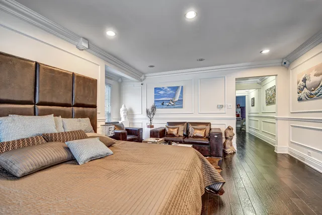 a spacious bedroom with a bed a table and painting on the wall