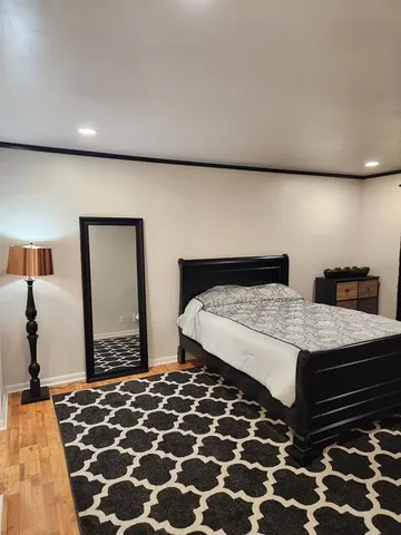 a bedroom with a bed and wooden floor