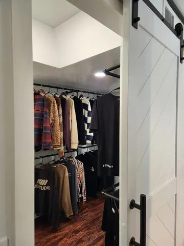 a view of walk in closet with clothes and shoes