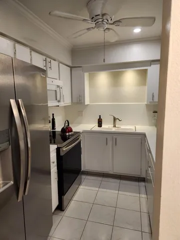 a kitchen with a sink a refrigerator and cabinets