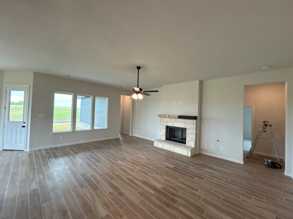8861 County Road 623 Blue Ridge, TX 75424 - Photo 8 of 20 an empty room with windows a fireplace and wooden floor