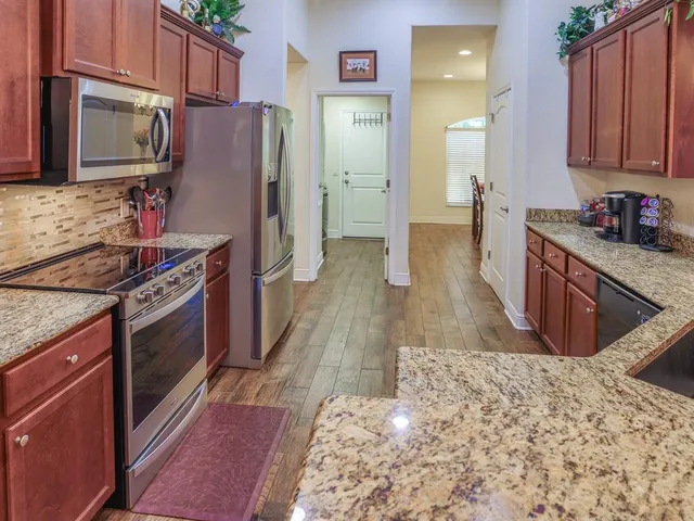 a kitchen with stainless steel appliances granite countertop a stove a refrigerator and a sink