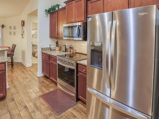 a kitchen with stainless steel appliances granite countertop a refrigerator stove and sink