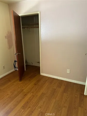 an empty room with wooden floor and closet