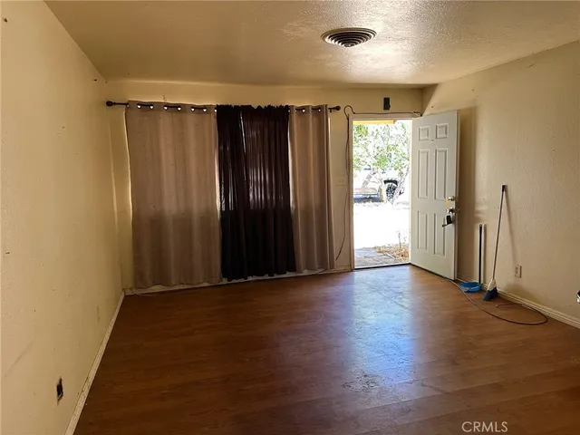 an empty room with wooden floor and a window