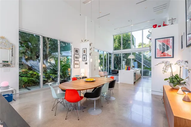 a living room with furniture a bookshelf and a window