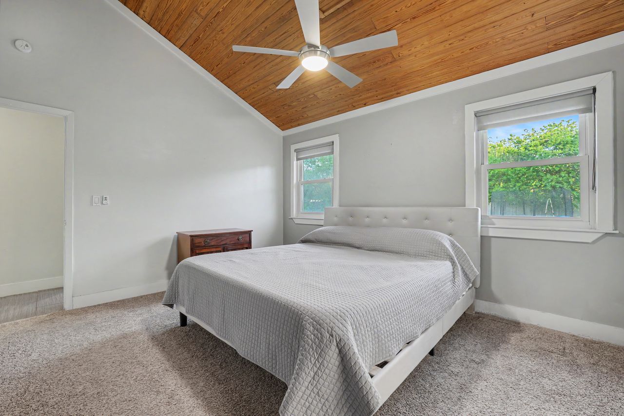 6903 Ardath Street Austin, TX 78757 - Photo 19 of 40 Bedroom with ceiling fan, a vaulted wooden ceiling, light carpet, and ornamental molding