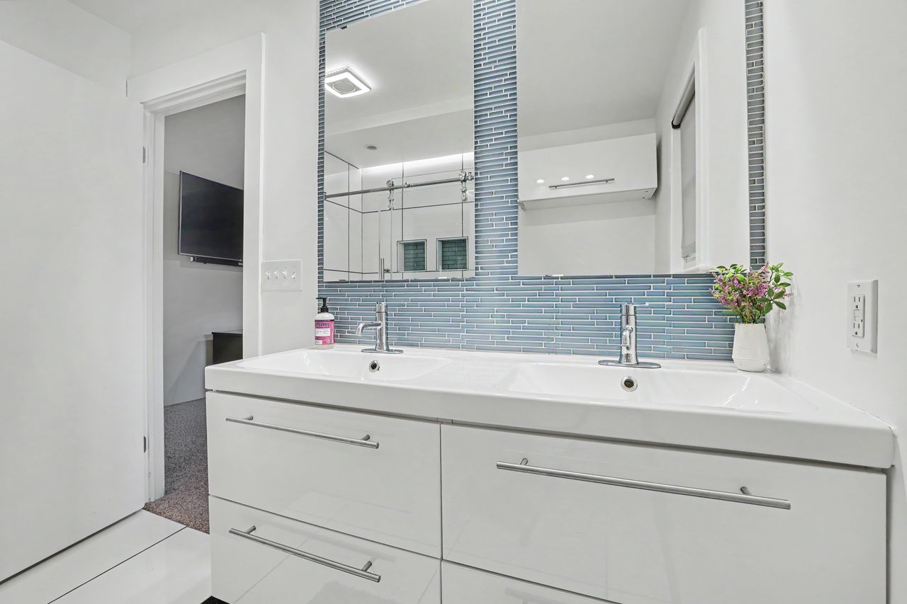 6903 Ardath Street Austin, TX 78757 - Photo 25 of 40 Bathroom featuring double vanity and decorative backsplash