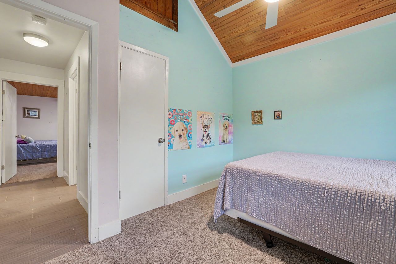 6903 Ardath Street Austin, TX 78757 - Photo 27 of 40 Bedroom with light carpet, wood ceiling, and a ceiling fan