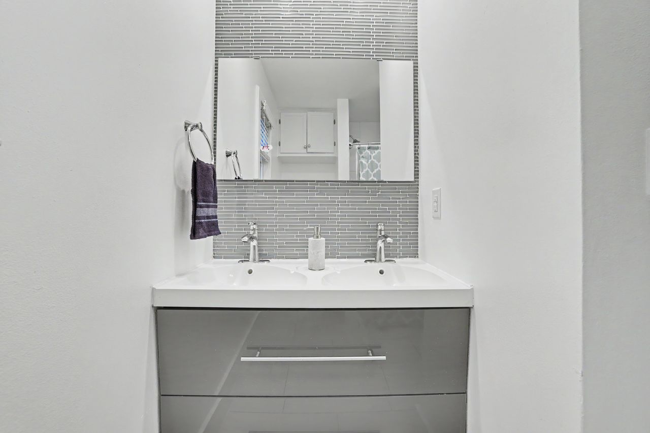 6903 Ardath Street Austin, TX 78757 - Photo 28 of 40 Bathroom with decorative backsplash, double vanity, and curtained shower