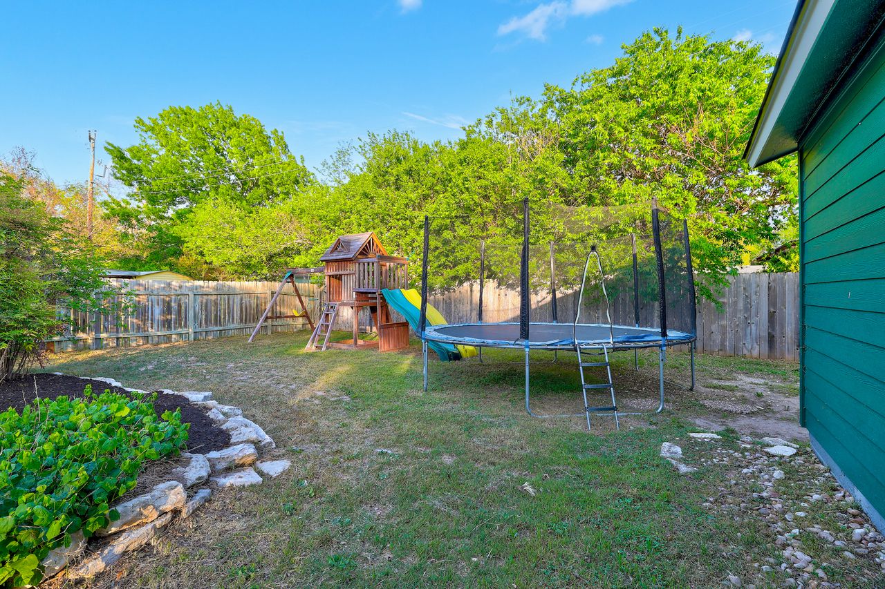 6903 Ardath Street Austin, TX 78757 - Photo 39 of 40 Fenced backyard featuring a playground and a trampoline