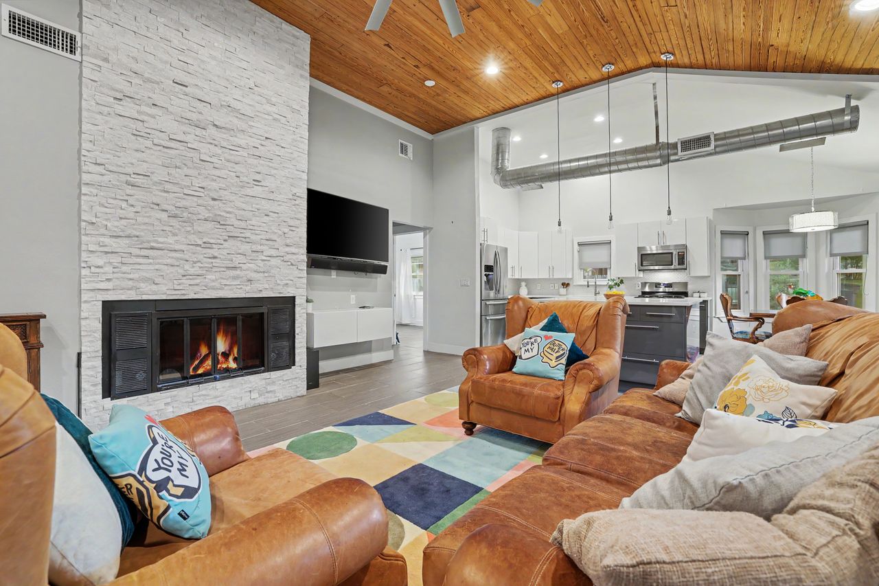 6903 Ardath Street Austin, TX 78757 - Photo 8 of 40 Living area featuring a high wood ceiling, recessed lighting, wood finished floors, a stone fireplace, and a ceiling fan