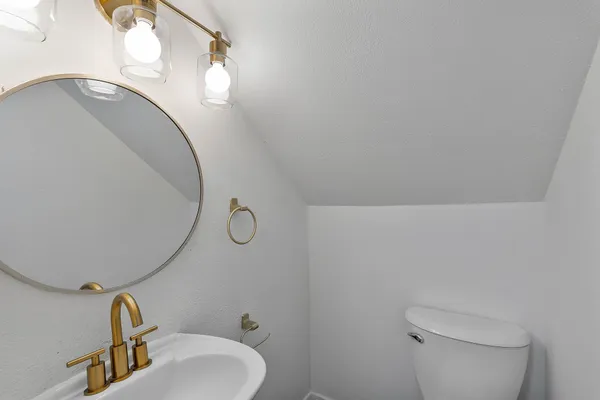 a bathroom with a sink mirror vanity and toilet