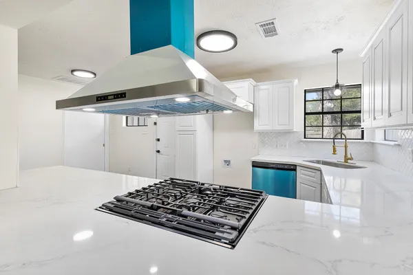 a kitchen with stainless steel appliances granite countertop a sink stove and cabinets