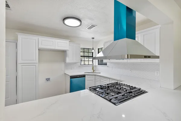 a kitchen with stainless steel appliances a stove a sink and a refrigerator