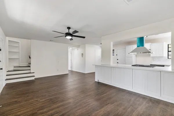 a large white kitchen with sink a stove and white cabinets