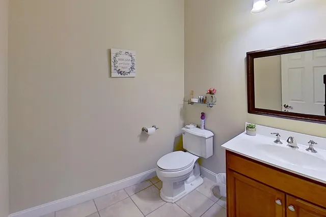 a bathroom with a toilet sink vanity and mirror