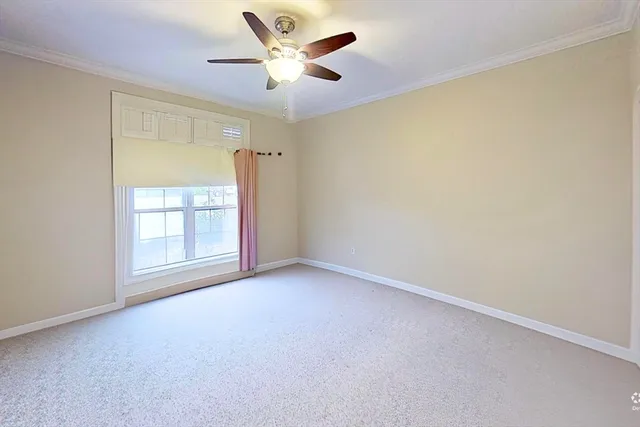 an empty room with a window and a ceiling fan