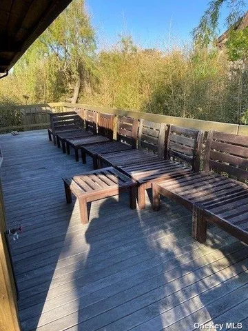 a view of a patio with table and chairs with wooden floor and fence
