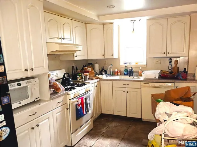 a kitchen with cabinets appliances a sink and a window
