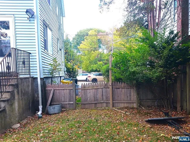 a view of a backyard with a trees and wooden fence