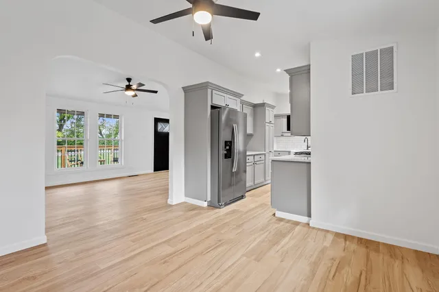 a view of a kitchen with refrigerator and wooden floor