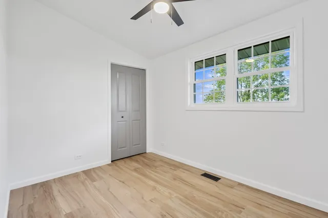 an empty room with a window and wooden floor