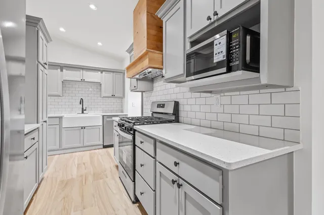a kitchen with a sink stove and cabinets