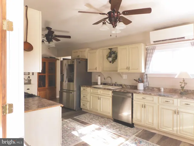 a kitchen with a sink cabinets stainless steel appliances and a window