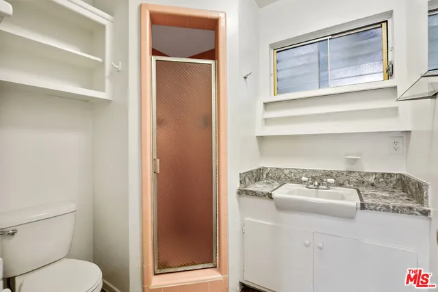a view of an empty room with wooden floor and a closet