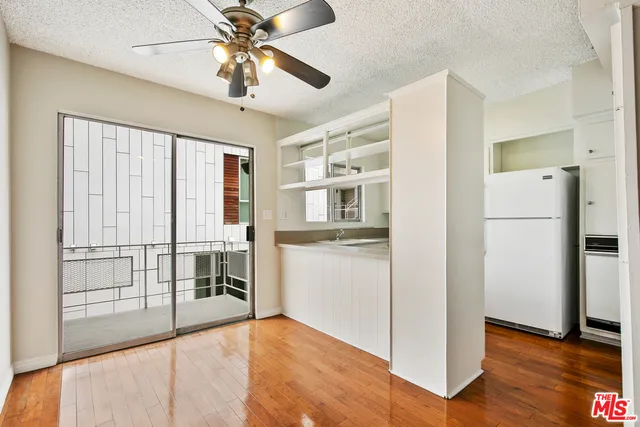 a view of a kitchen with a refrigerator and a stove top oven