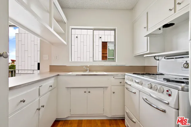 a kitchen with granite countertop a sink stainless steel appliances and cabinets