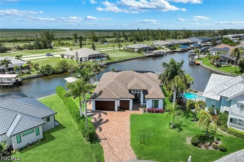 an aerial view of a house with a garden and lake view