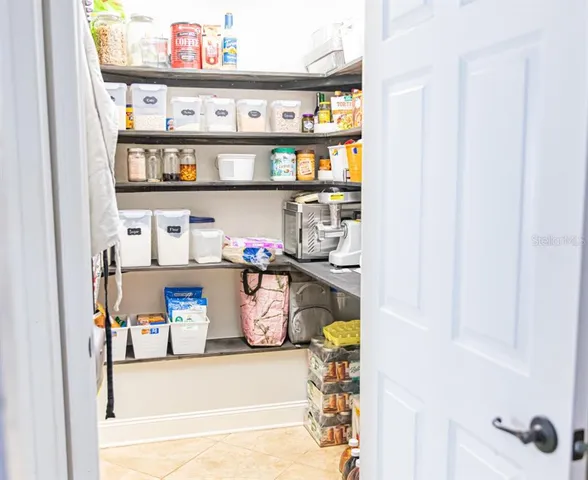 a view of a dining room with a baby crib and a book shelf