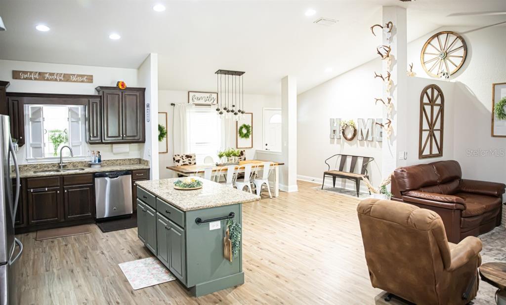 1533 County Road 13 Bunnell, FL 32110 - Photo 9 of 49 a living room with granite countertop furniture a rug kitchen view and a wooden floor