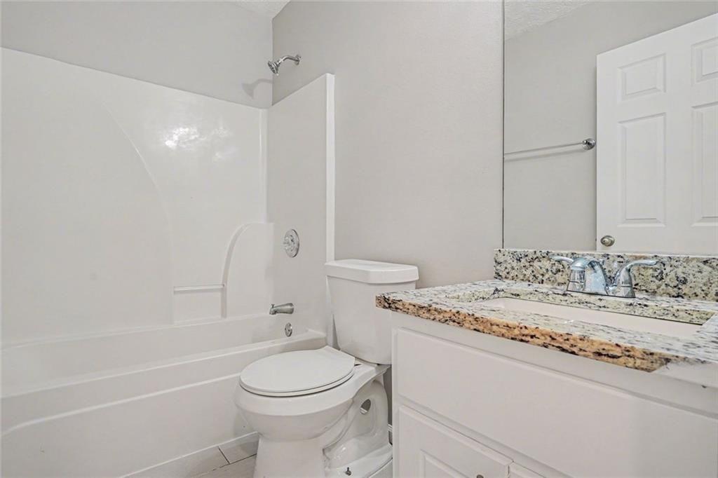 10 Wilbur Way Covington, GA 30016 - Photo 10 of 22 a bathroom with a granite countertop sink toilet and shower