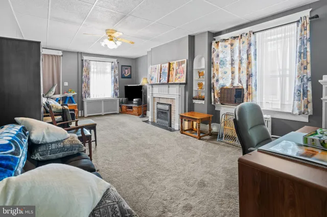 a living room with furniture a fireplace and a large window