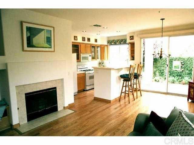 442 Carmel Creeper Place Encinitas, CA 92024 - Photo 2 of 12 a living room with stainless steel appliances kitchen island granite countertop furniture and a fireplace