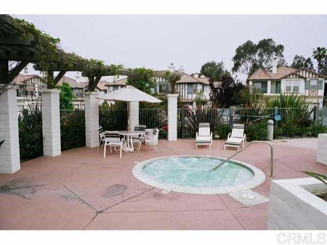 442 Carmel Creeper Place Encinitas, CA 92024 - Photo 10 of 12 a view of a patio with dining table and chairs under an umbrella
