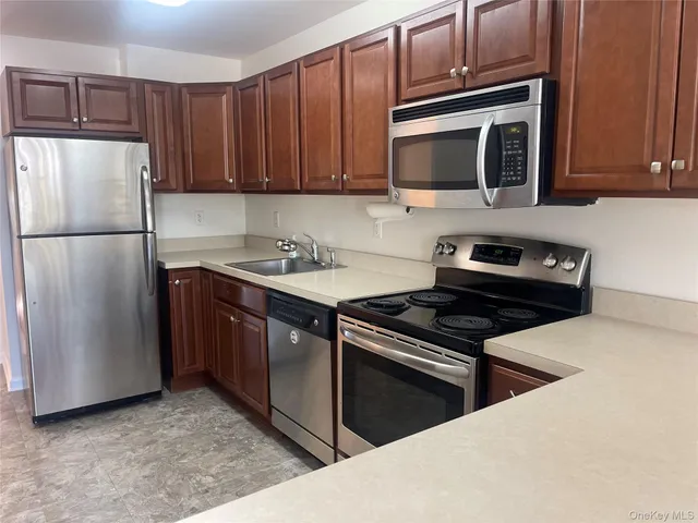 a kitchen with stainless steel appliances a stove a microwave and a sink